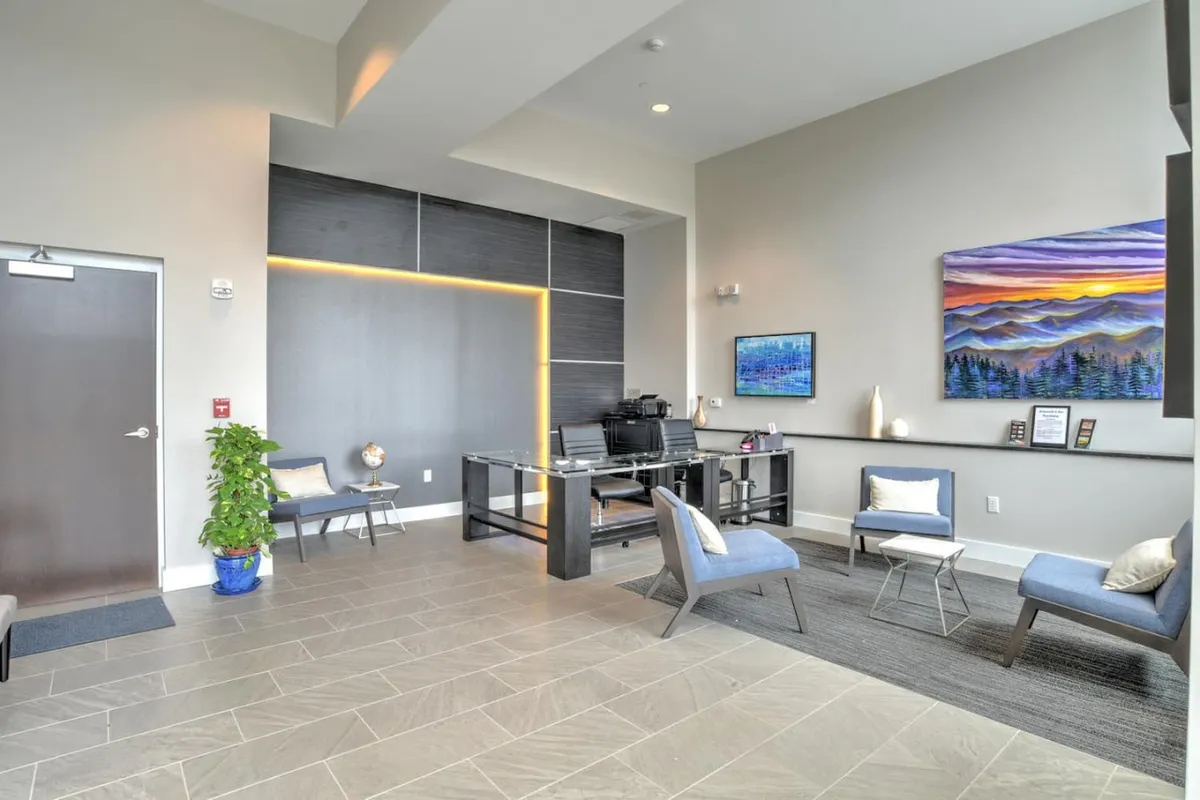 This image captures the building's inviting lobby, featuring a contemporary reception desk, tasteful artwork, and a comfortable seating area. The lobby is brightly lit and exudes a professional yet welcoming atmosphere, setting the tone for a secure and pleasant arrival.